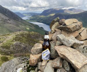 Bottle of Wainwright Gold at the top of Haystacks looking down to Buttermere