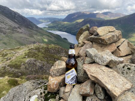 Bottle of Wainwrights Gold at the top of Haystacks looking down to Buttermere